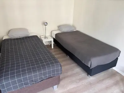 two beds in a small bedroom with a lamp at Appartement 3chambres en plein centre-ville in Brussels