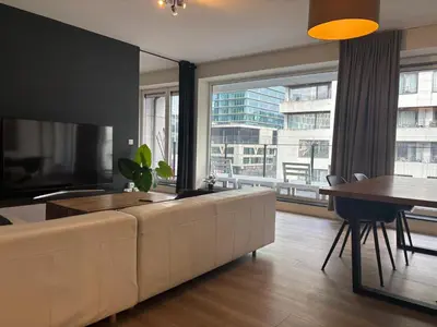 a living room with a couch and a large window at Appartement 3chambres en plein centre-ville in Brussels