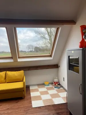 a room with a yellow couch and a window at Vakantiewoning centraal in België, veel privacy, prachtig uitzicht, airco in Denderleeuw