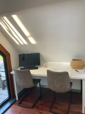 a desk with two chairs and a computer on it at Vakantiewoning centraal in België, veel privacy, prachtig uitzicht, airco in Denderleeuw