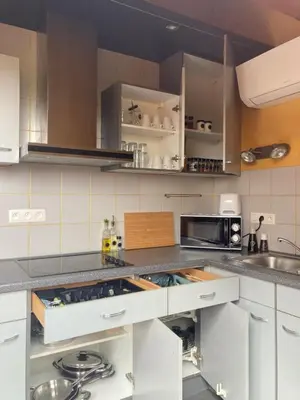 a kitchen with white cabinets and a sink and a microwave at Vakantiewoning centraal in België, veel privacy, prachtig uitzicht, airco in Denderleeuw