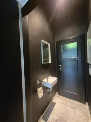 a bathroom with a black door and a sink at Résidence Souverain 94 in Brussels