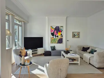 a living room with a couch and a tv at Souverain 94 in Brussels
