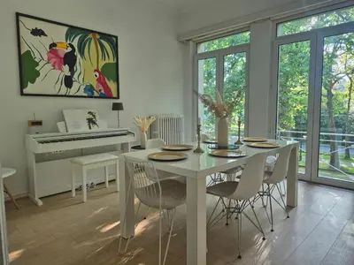 a dining room with a white table and a piano at Souverain 94 in Brussels