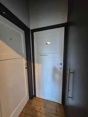 a hallway with a white door and a door with a window at Souverain 94 in Brussels