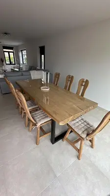 a wooden dining room table with chairs and a couch at Sœur in Berlare