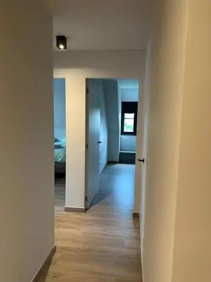 an empty room with a hallway leading to a bedroom at Sœur in Berlare