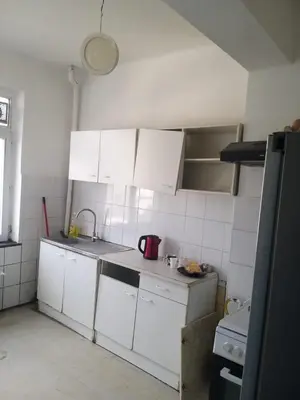 a kitchen with white cabinets and a sink at Hébergement confort Garé de l'ouest in Brussels