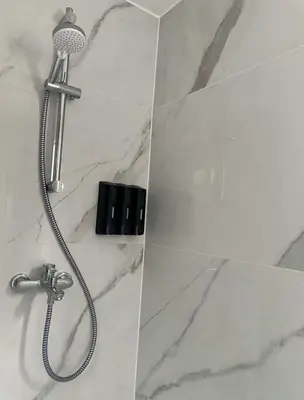 a shower with a shower head in a bathroom at Grand appartement deux chambres in Brussels