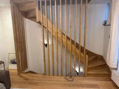 a staircase with wooden railings in a living room at DePearl in Brussels