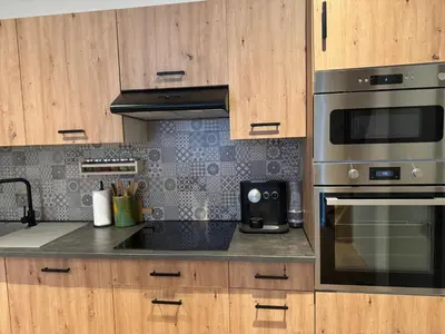 a kitchen with stainless steel appliances and wooden cabinets at DePearl in Brussels