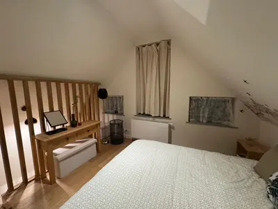 a bedroom with a bed and a desk and a window at DePearl in Brussels