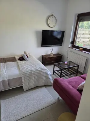 a bedroom with a bed and a clock on the wall at Studio cozy avec terrasse in Vilvoorde