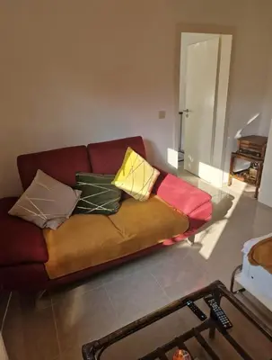 a couch with pillows on it in a living room at Studio cozy avec terrasse in Vilvoorde