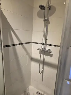 a shower with a shower head in a bathroom at Studio cozy avec terrasse in Vilvoorde
