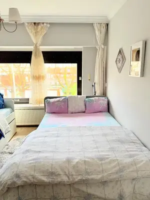 a bedroom with a large bed in front of a window at Ngipe's Tomorrowland in Antwerp