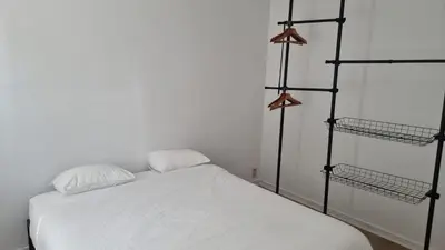 a bedroom with a white bed with three shelves at Maison Agathe in Brussels