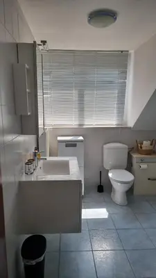 a white bathroom with a toilet and a sink at Maison Agathe in Brussels