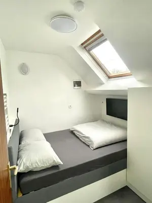 a small bedroom with a bed and a skylight at Green Spot Meise - 15 min from Brussels with free parking & Self check-in in Meise