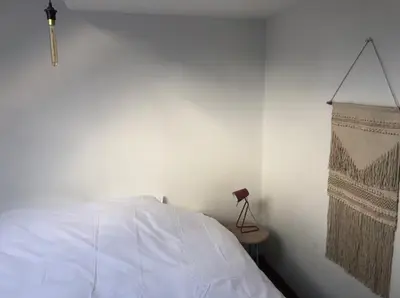 a bedroom with a white bed and a lamp at Cozy & Spacious Duplex with an Amazing Terrace in Antwerp