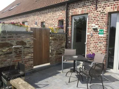 a patio with a table and chairs in front of a brick building at Luttelkolen in Holsbeek
