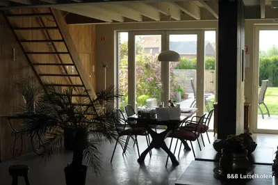 a dining room with a table and chairs with a plant at Luttelkolen in Holsbeek