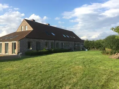 a large brick building with a large grass yard at Luttelkolen in Holsbeek