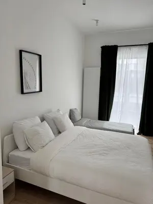 a white bed in a bedroom with a window at Bora Apartment in Brussels