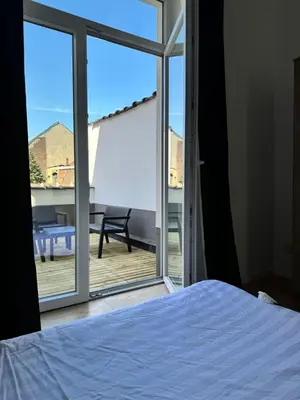 a bedroom with a bed and a view of a patio at MIDI cozy apartment in Brussels