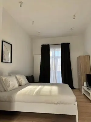 a bedroom with a white bed and a window at MIDI cozy apartment in Brussels