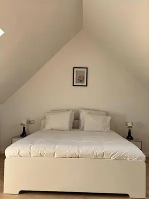 a white bed with white pillows in a attic at Loft Luna Brussels Midi in Brussels