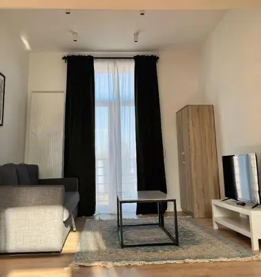 a living room with a couch and a tv at Loft Luna Brussels Midi in Brussels