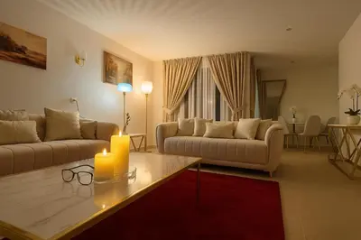 a living room with two couches and a table with a candle at OneLuxStay near Antwerp Central in Antwerp