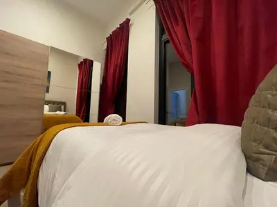 a bedroom with a white bed with red curtains at OneLuxStay near Antwerp Central in Antwerp