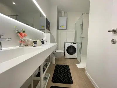 a bathroom with a toilet and a washing machine at OneLuxStay near Antwerp Central in Antwerp