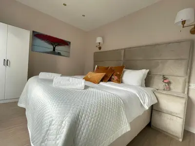 a bedroom with a large white bed with a large headboard at OneLuxStay near Antwerp Central in Antwerp