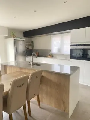a kitchen with a counter with chairs and a sink at MaïTyNa - Tomorrowland Stay in Rumst