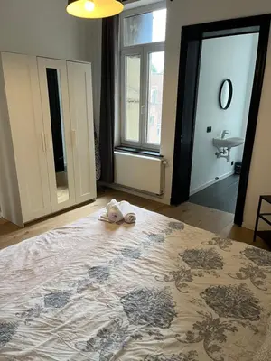 a bedroom with a bed with a stuffed animal on it at Flat south Brussels in Brussels