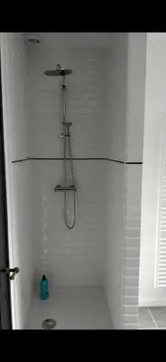 a shower in a bathroom with white tiles at Flat south Brussels in Brussels