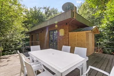 a table and chairs on a deck with a cabin at Chalet & Spa Nora in Stekene