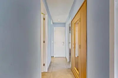 a hallway with blue walls and a door and a tile floor at Chalet & Spa Nora in Stekene