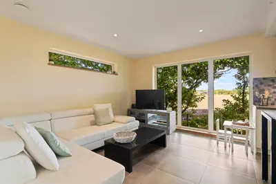 a living room with a white couch and a tv at Chalet & Spa Nora in Stekene