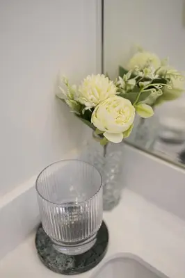 a vase with flowers on a counter in front of a mirror at Apartment in the hyper-center in Brussels