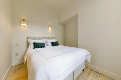 a white bedroom with a large white bed at Apartment in the hyper-center in Brussels
