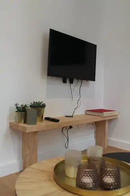 a flat screen tv sitting on top of a wooden table at The Antwerp Cathedral suite first floor in Antwerp