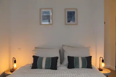 a bed with two pillows and two pictures on the wall at The Antwerp Cathedral suite first floor in Antwerp