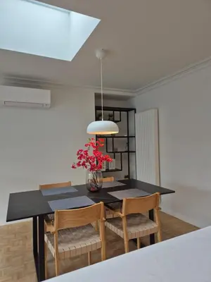 a dining room with a table with chairs and a vase of flowers at Huis ALNA 8 in Mechelen