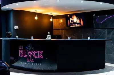 a black bar with a sign that reads blixyu spa service rate at Blvck Spa in Brussels