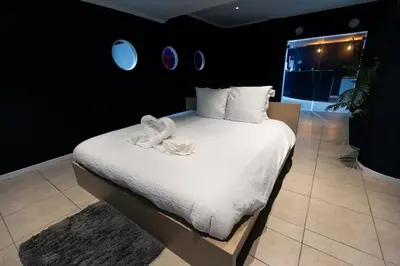 a bedroom with a large bed with white sheets and pillows at Blvck Spa in Brussels