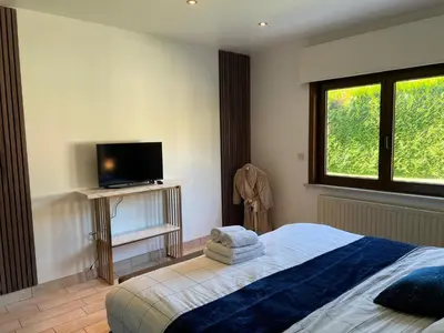 a bedroom with a bed and a flat screen tv at Villa op de hoek Rooms in Aalst